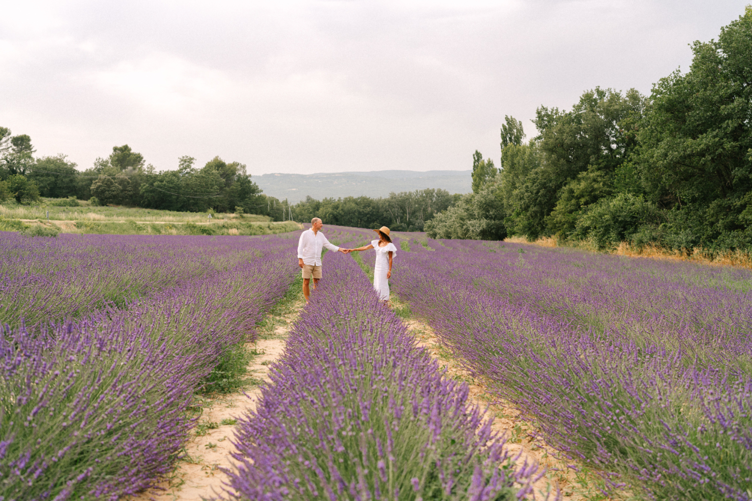 man and woman in hat pose in lavender field