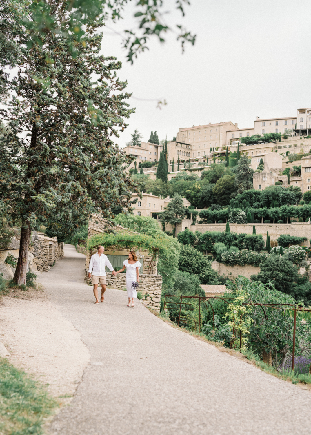 couple dressed in white walk in gordes france