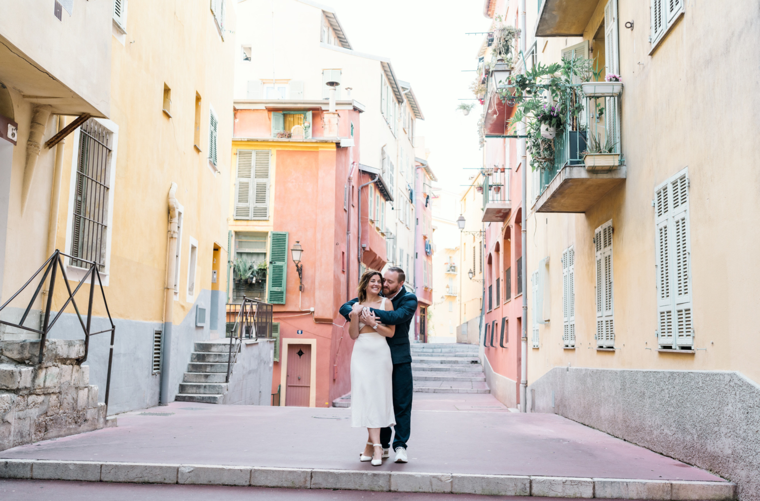 married couple embrace in colorful neighborhood in nice france