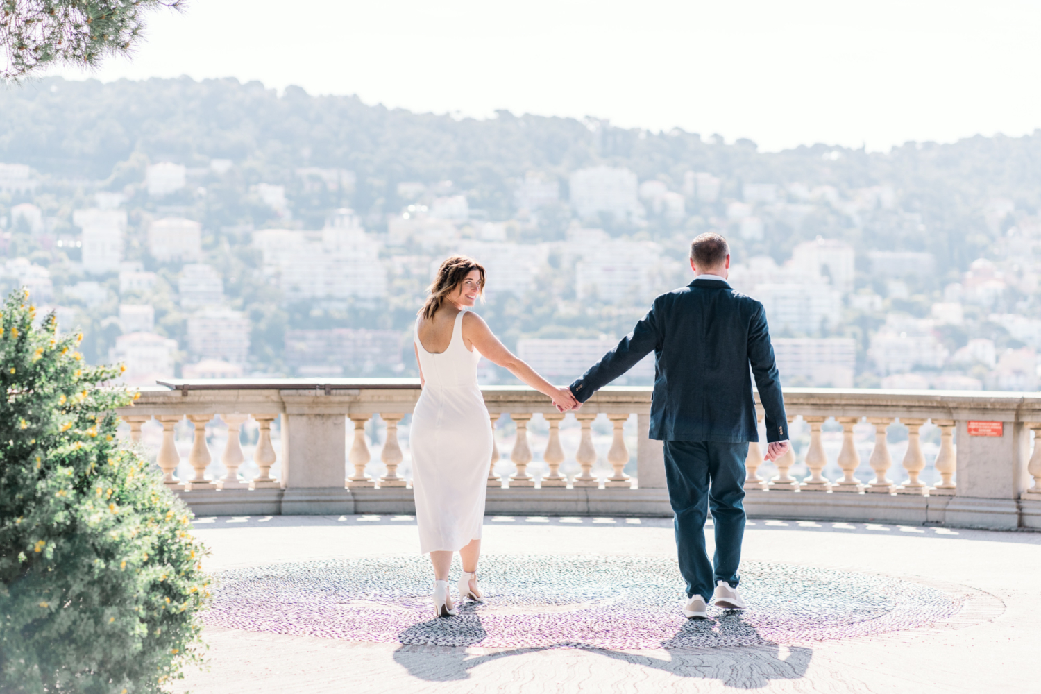 woman smiles at camera as she walks with man castle hill nice