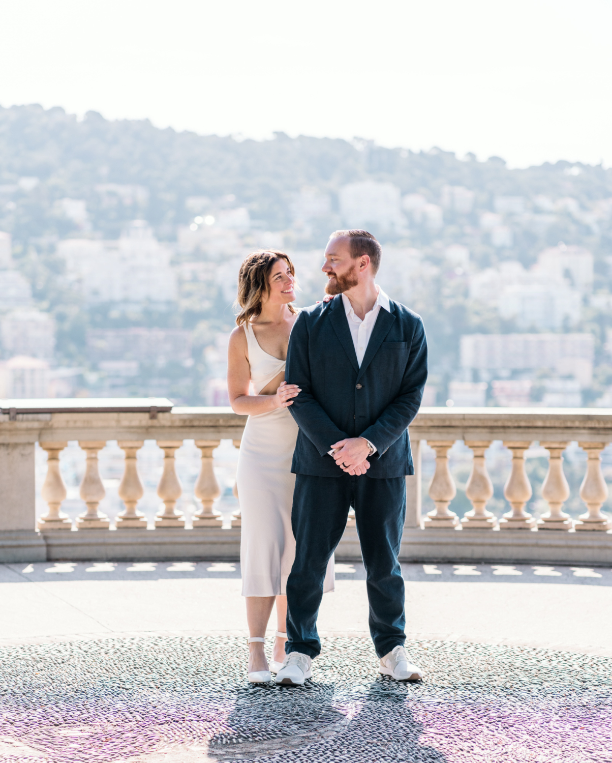 couple smile at each other lovingly with beautiful view of mountains