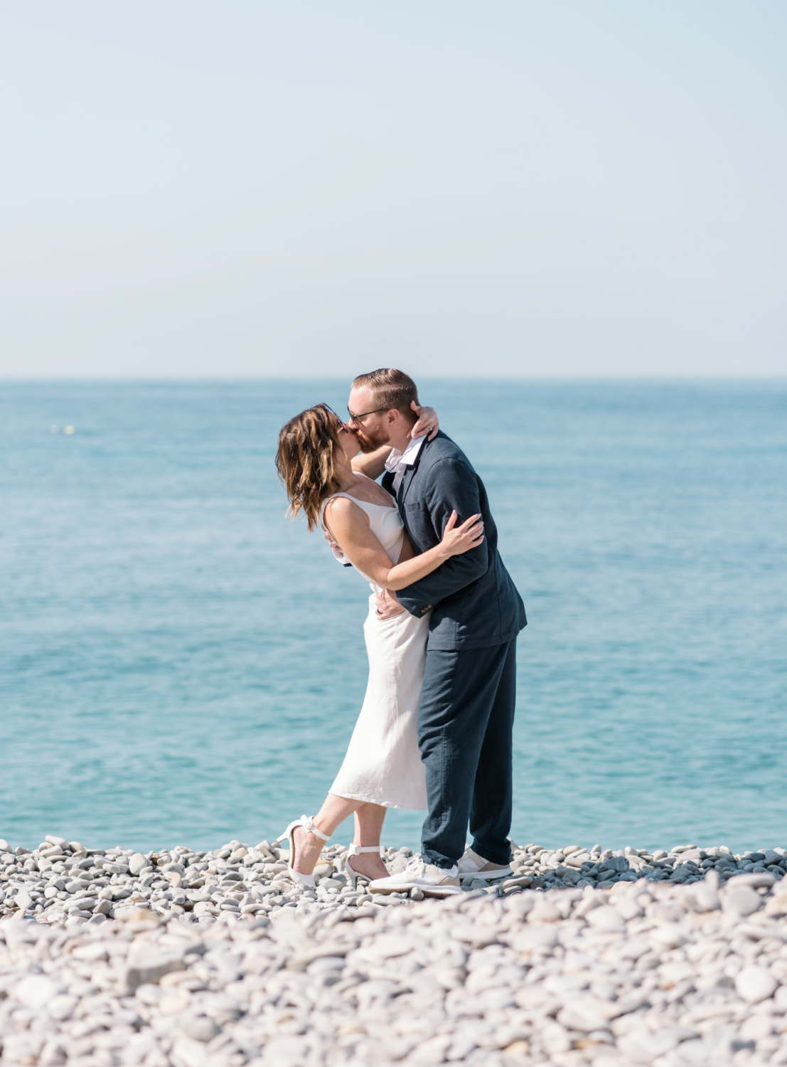 man and woman embrace and kiss next to sea in nice france