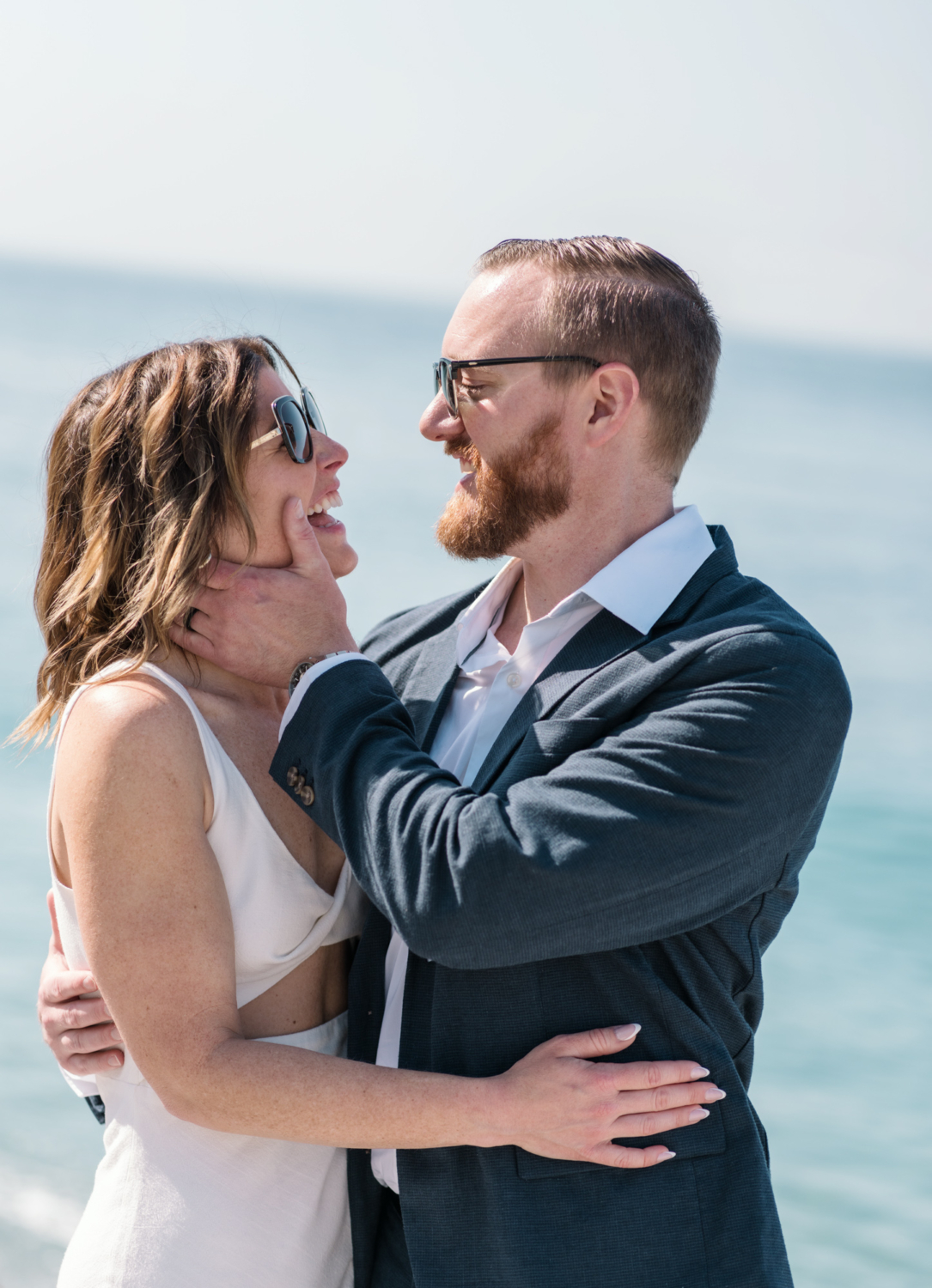 man touches womans cheek as she laughs in nice france