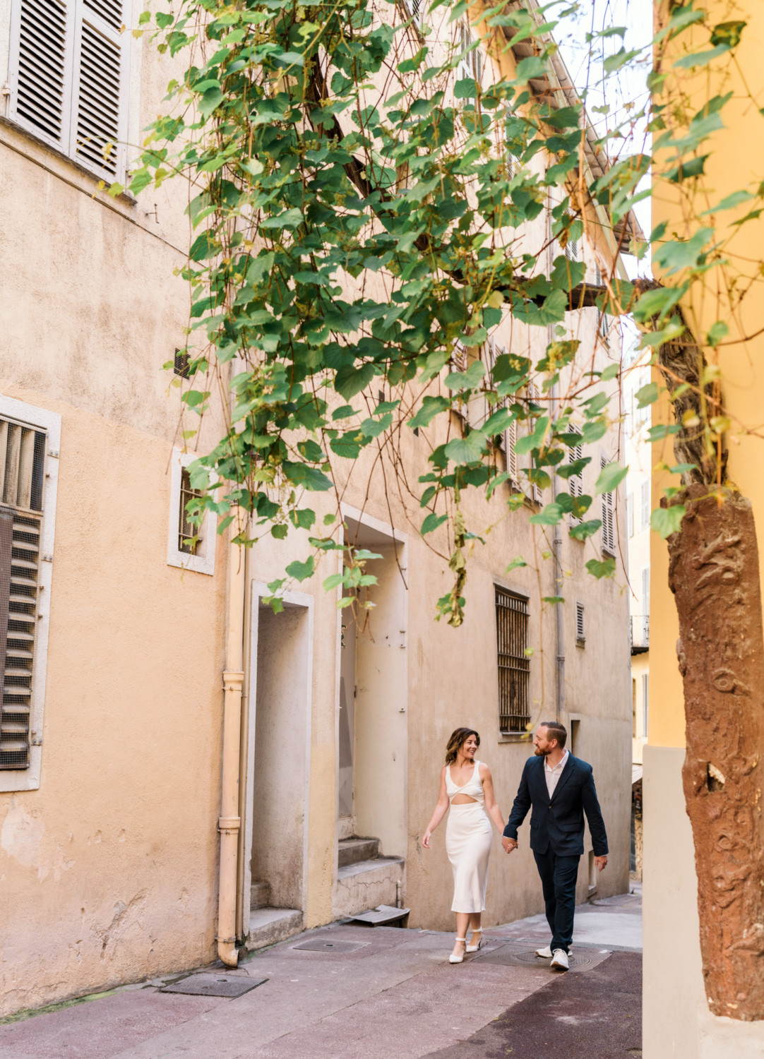 man and woman walk together in colorful neighborhood in old nice france