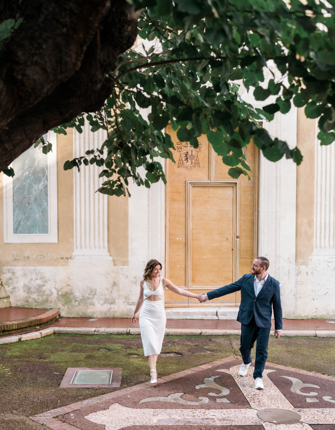 man and woman walk holding hands near church in nice france