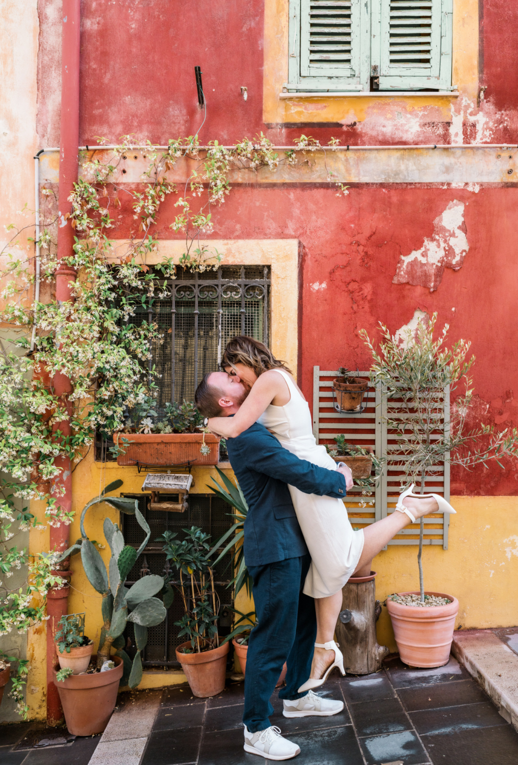 man lifts woman in air in colorful neighborhood in nice france