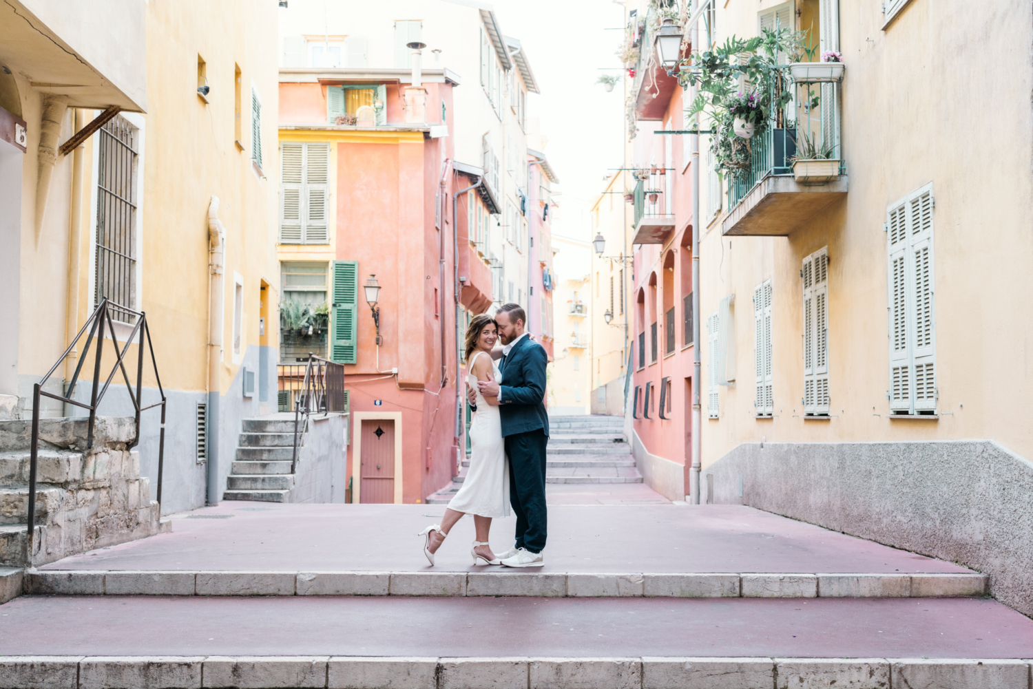 married couple embrace in colorful neighborhood in nice france