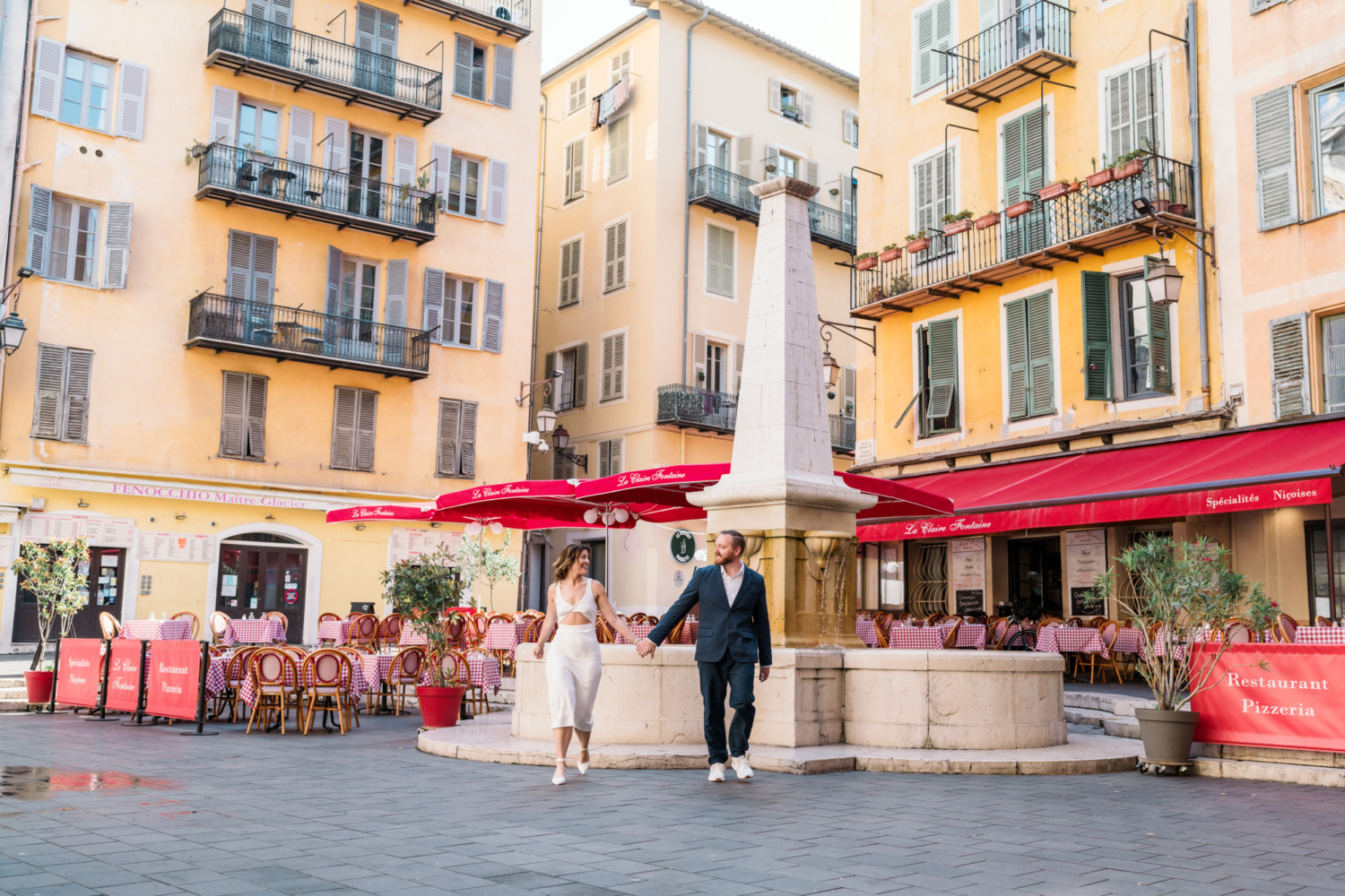 happy couple walk next to italian restaurant in old nice france