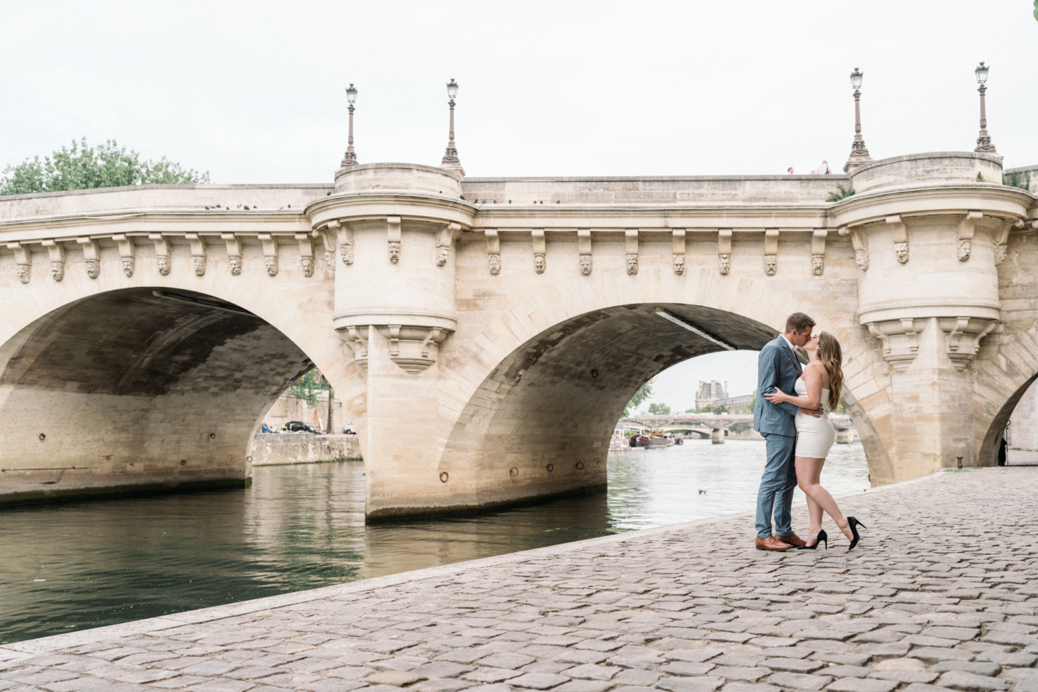 engaged couple kiss passionately at pont neuf bridge in paris