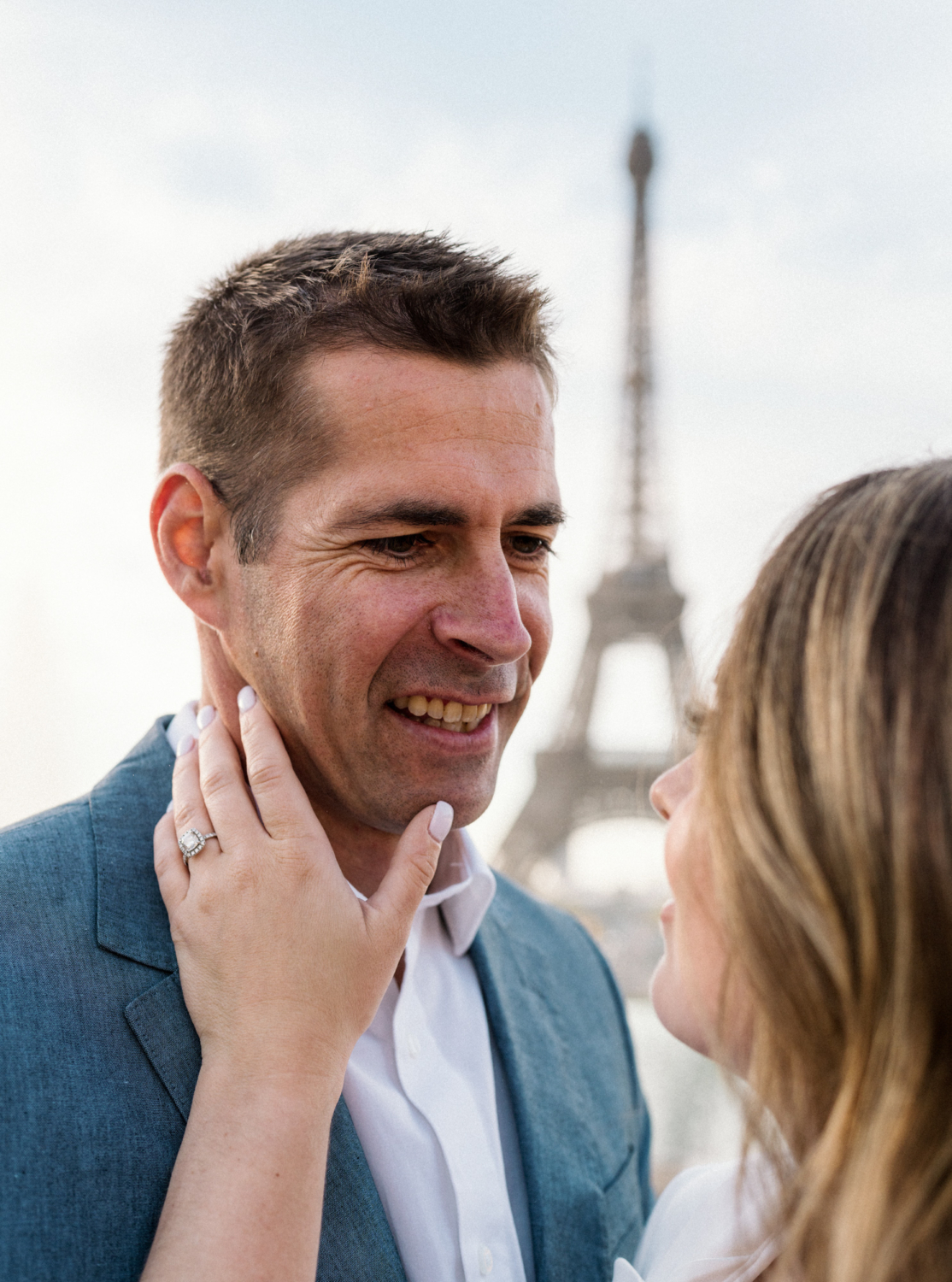 man smiles at woman with eiffel tower in background