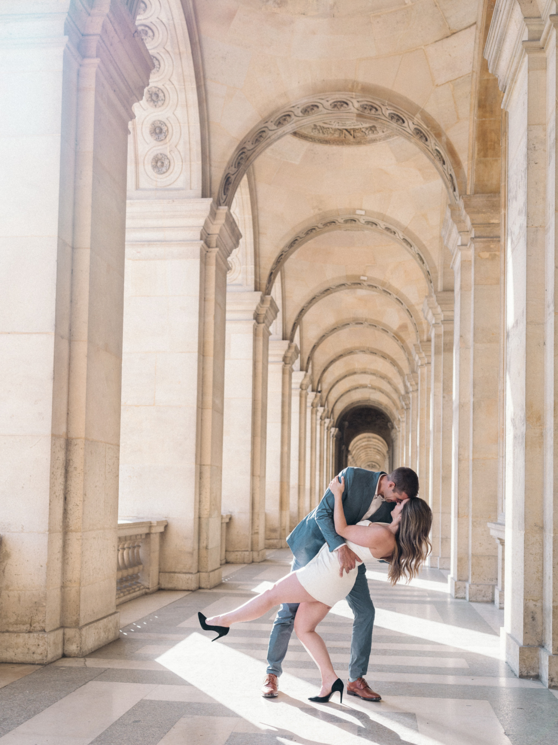 man dips woman in the corridor of the louvre museum in paris