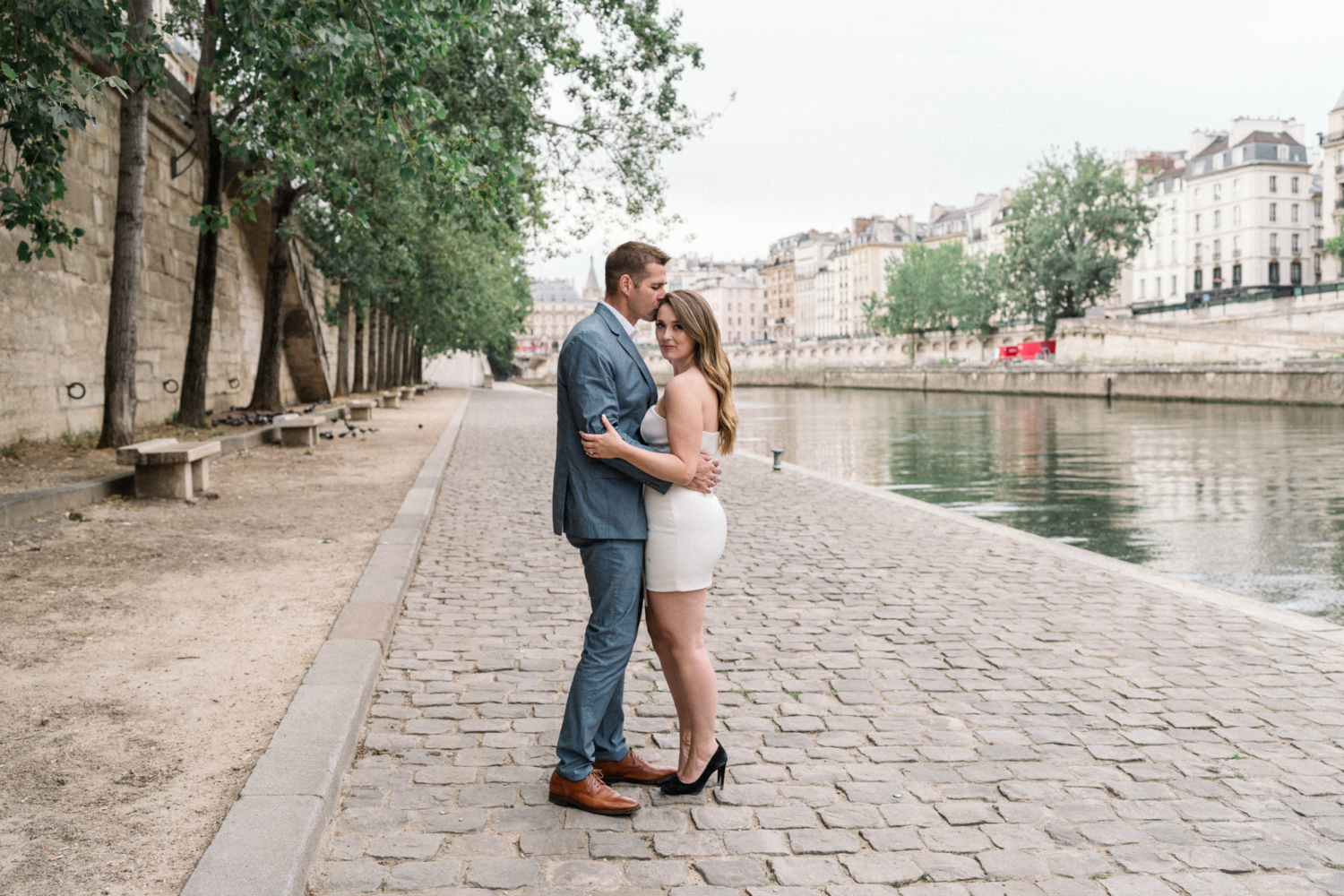 engaged couple embrace with view of paris in background during Engagement Photos In Paris