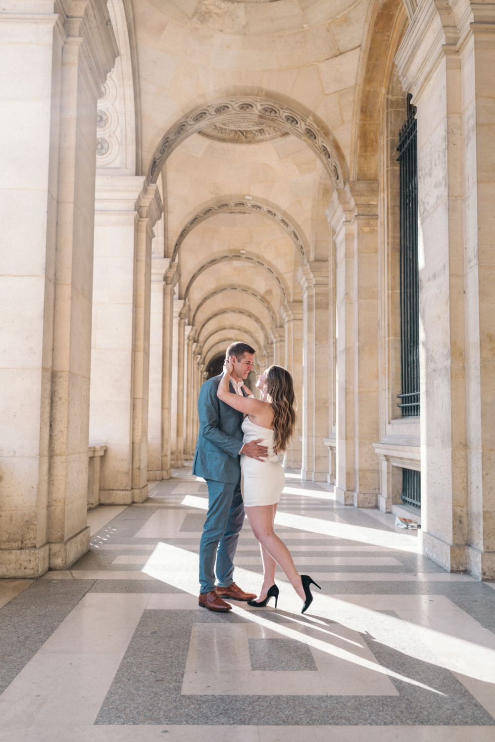 engaged couple embrace at the louvre in paris france