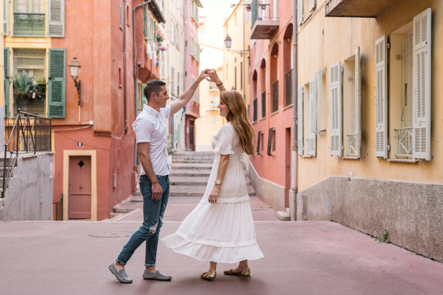 man twirls woman in colorful neighborhood in nice france