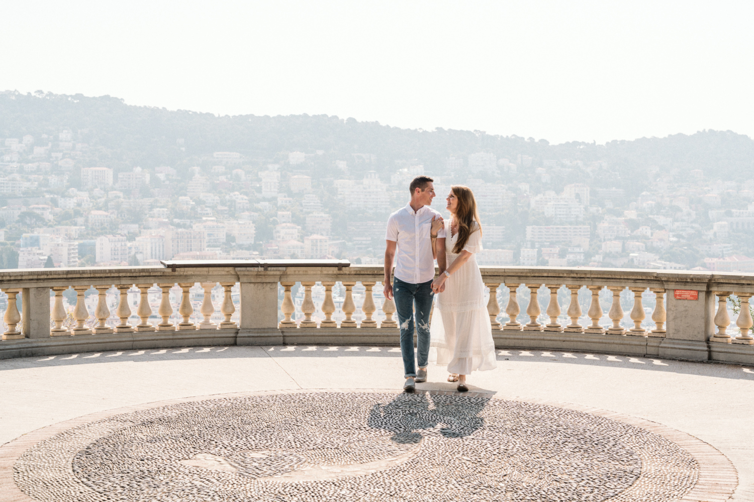 smiling couple walk arm in arm in nice france