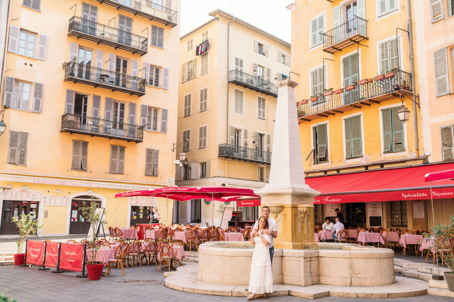 cute couple pose in front of italian restaurant in old town nice france