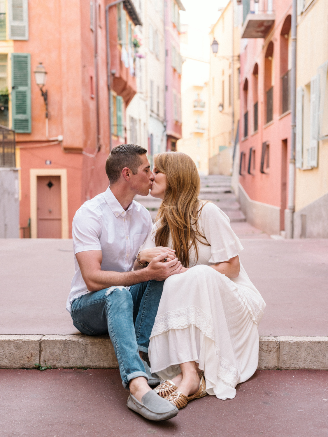 couple share cute kiss on streets of old town nice france