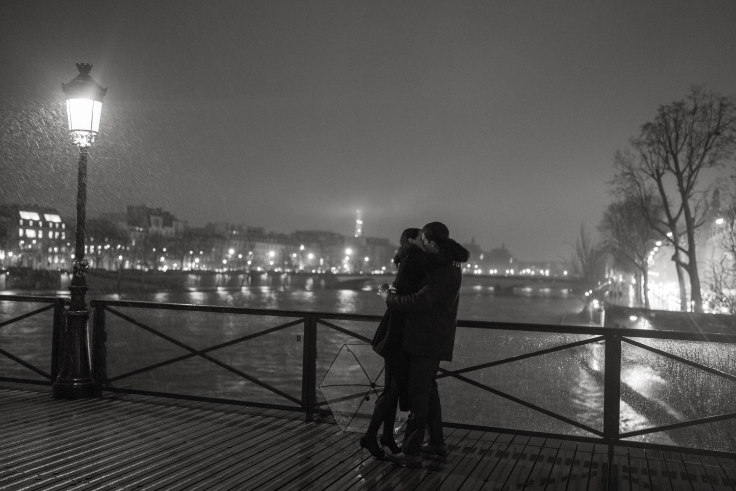 engaged couple kiss in the rain in paris