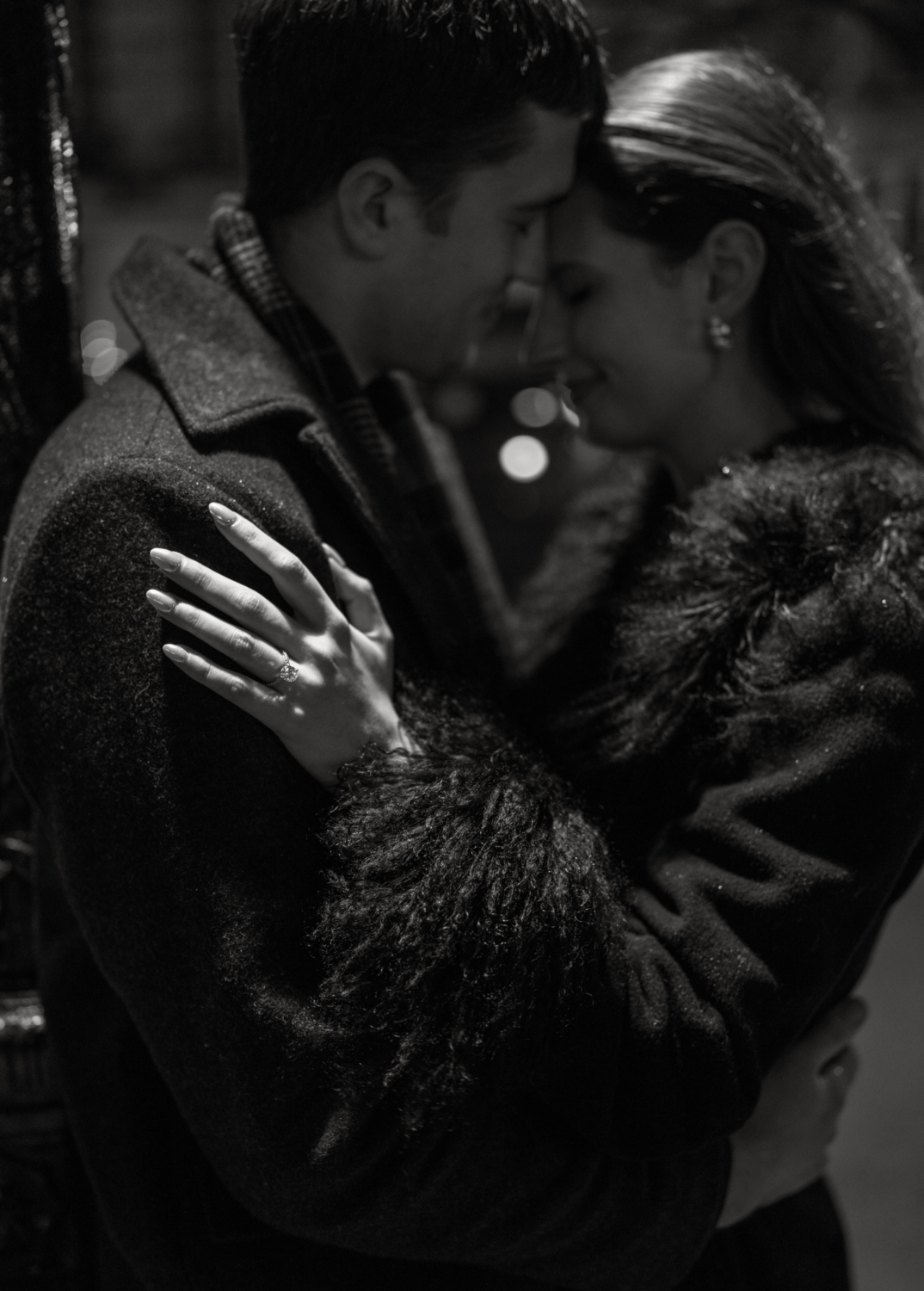 engaged couple touch heads at place dauphine at night in paris