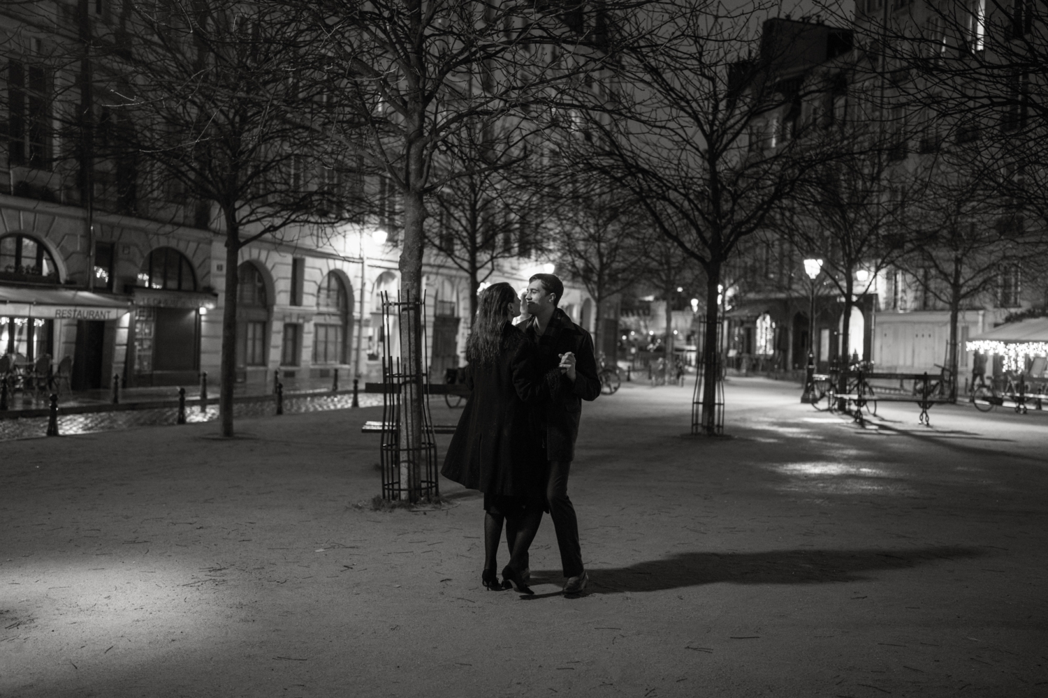 engaged couple dance at place dauphine at night in paris