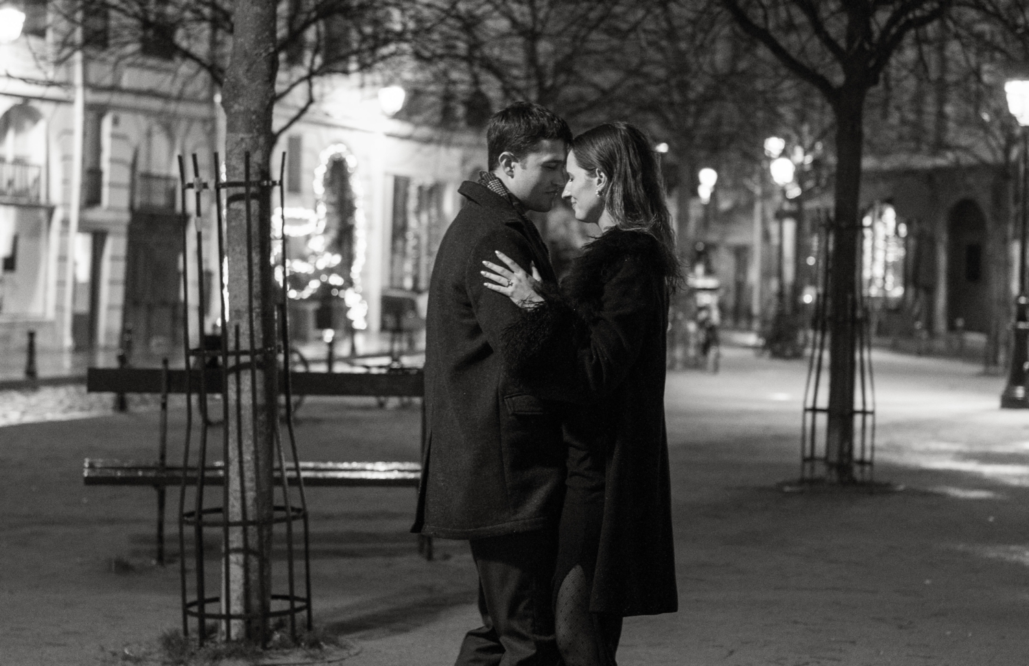 engaged couple hung at place dauphine at night in paris