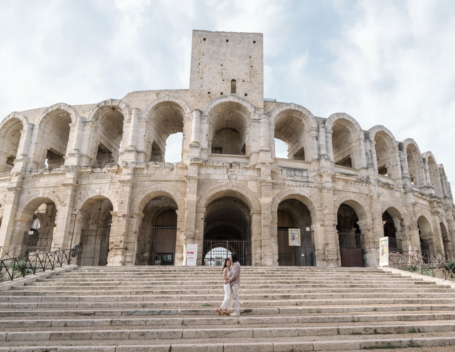 couple pose in front of old amphitheatre in arles france