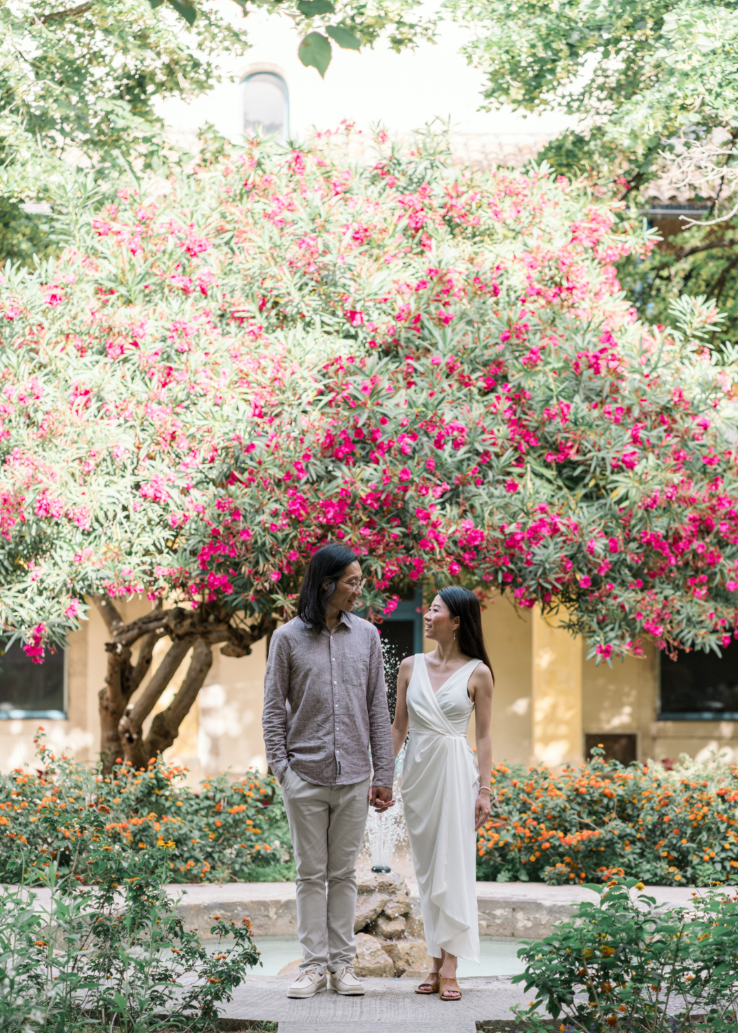 chinese couple hold hands in beautiful garden in arles france