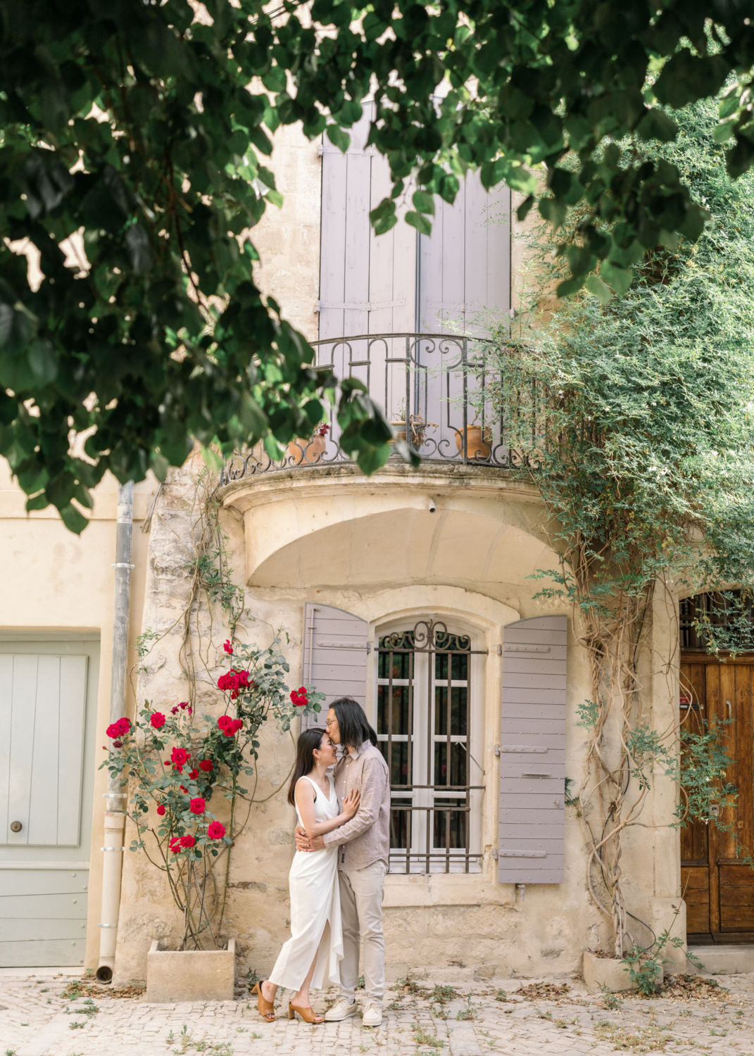 man kisses woman's forehead in cute neighborhood scene in arles france