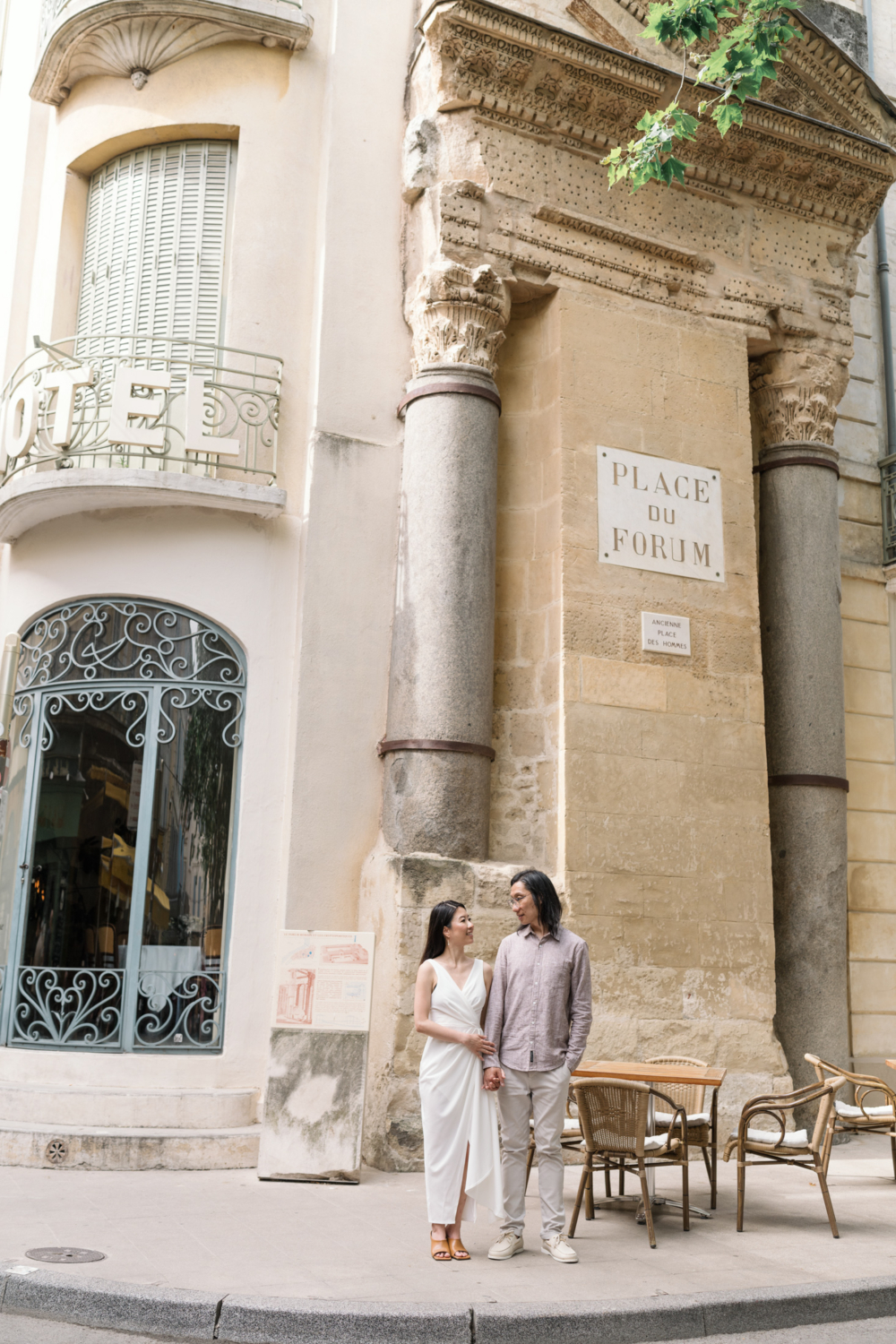 chinese couple pose in front of place du forum in arles france