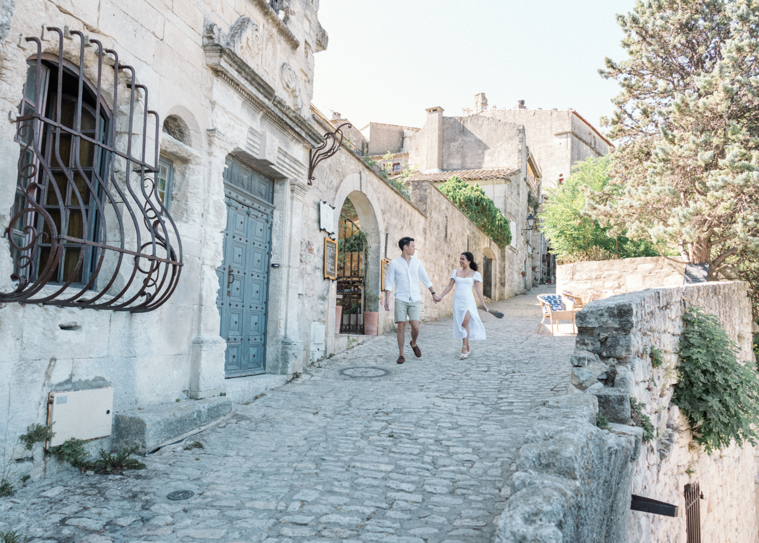 couple walk through medieval village hand in hand les baux de provence