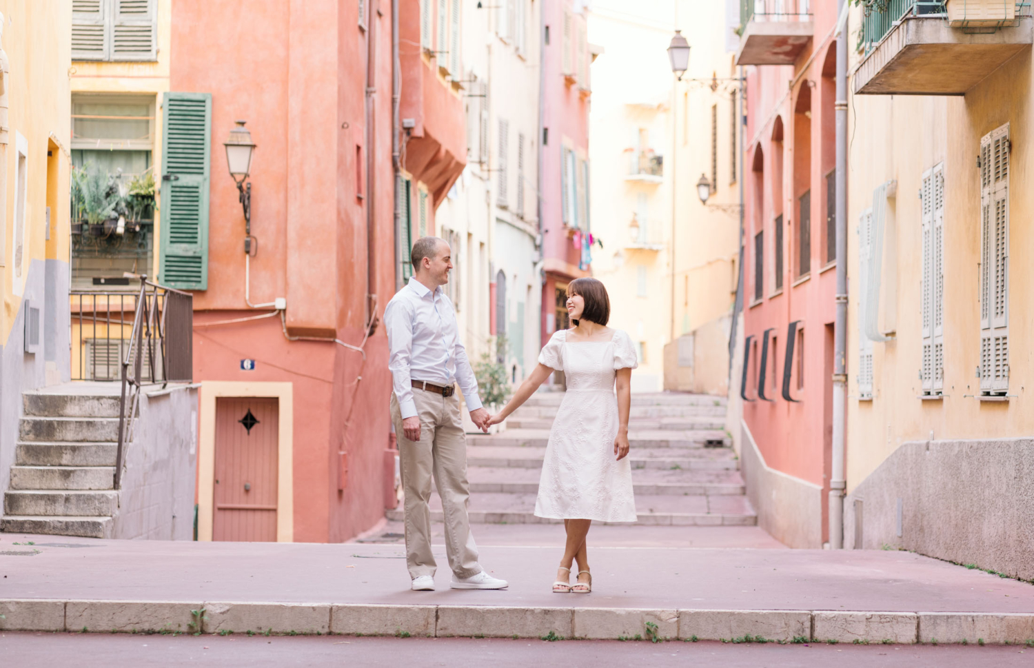 cute couple pose in old town nice france surrounded by colorful buildings