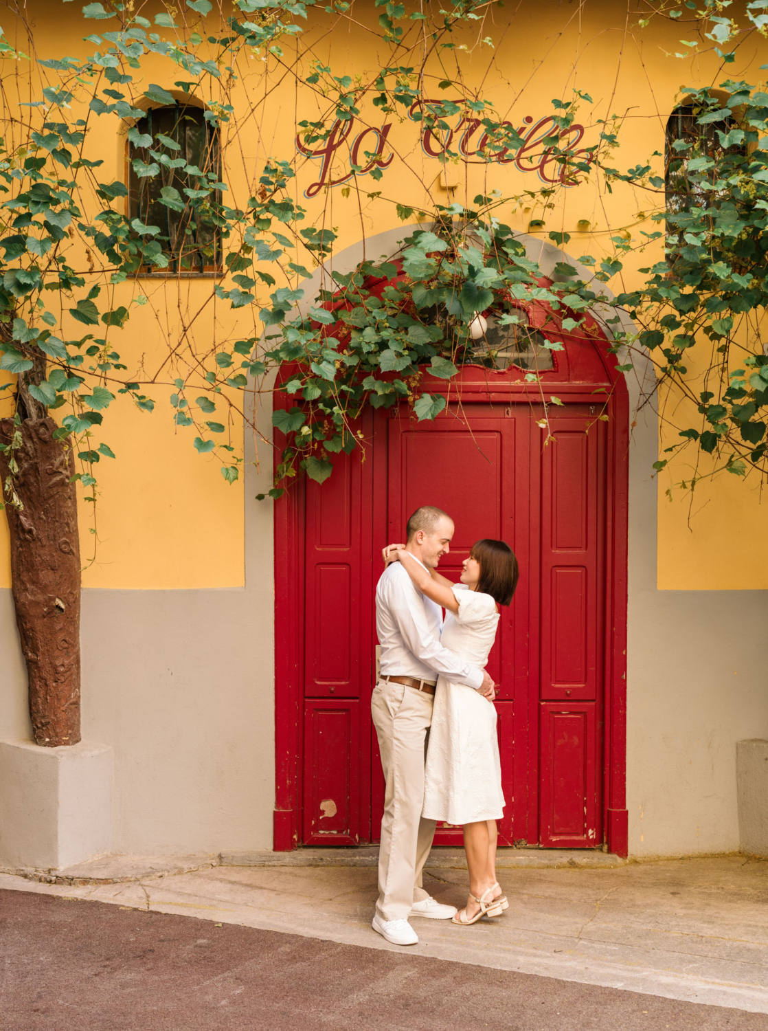 man and woman embrace in front of red door in old town nice france