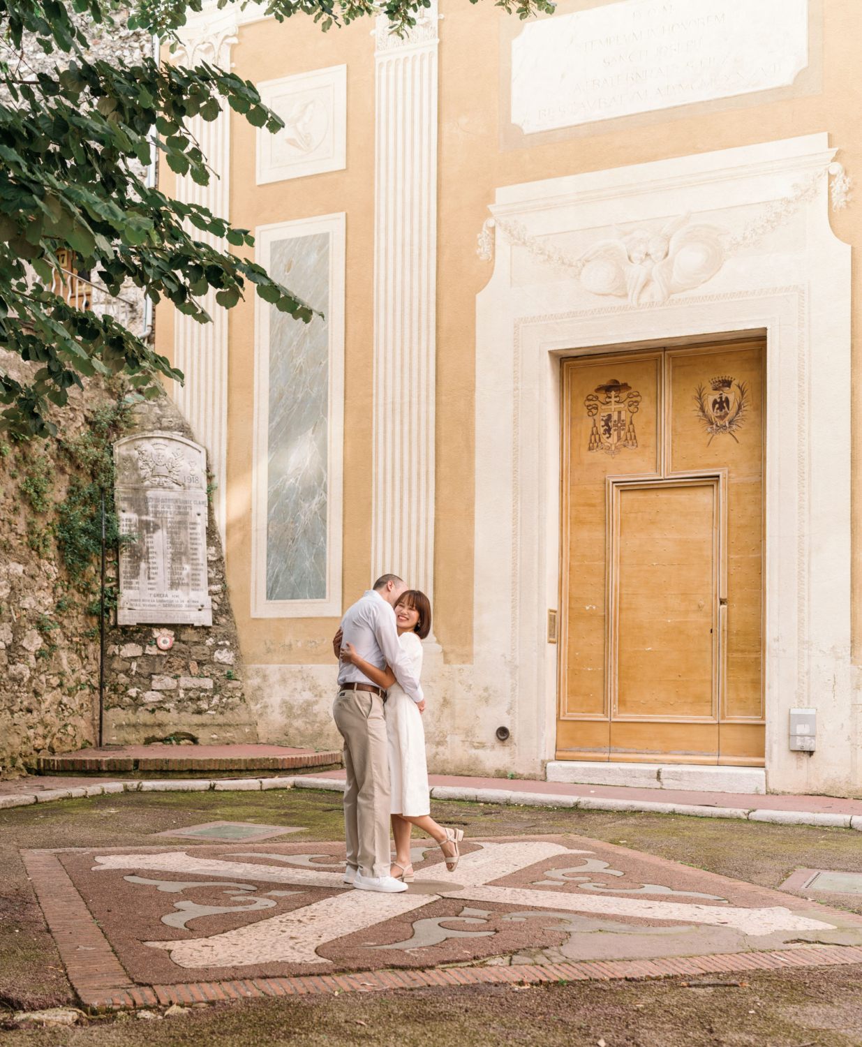 couple in love embrace in front of yellow church in nice france