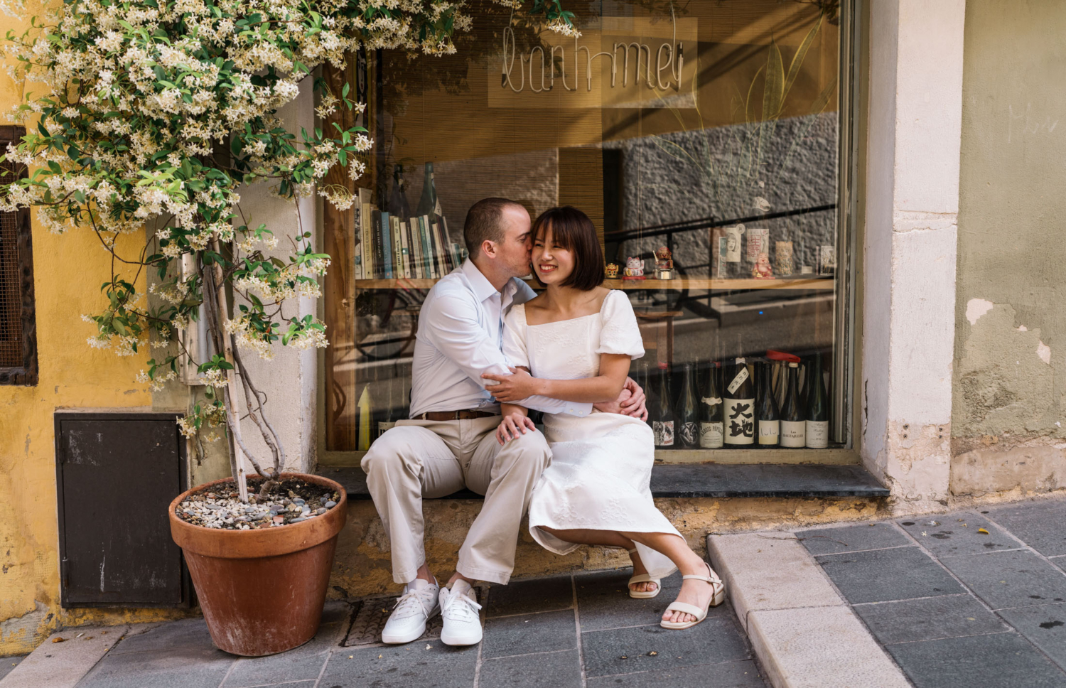 man kisses womans ear seated next to jasmine tree in nice france