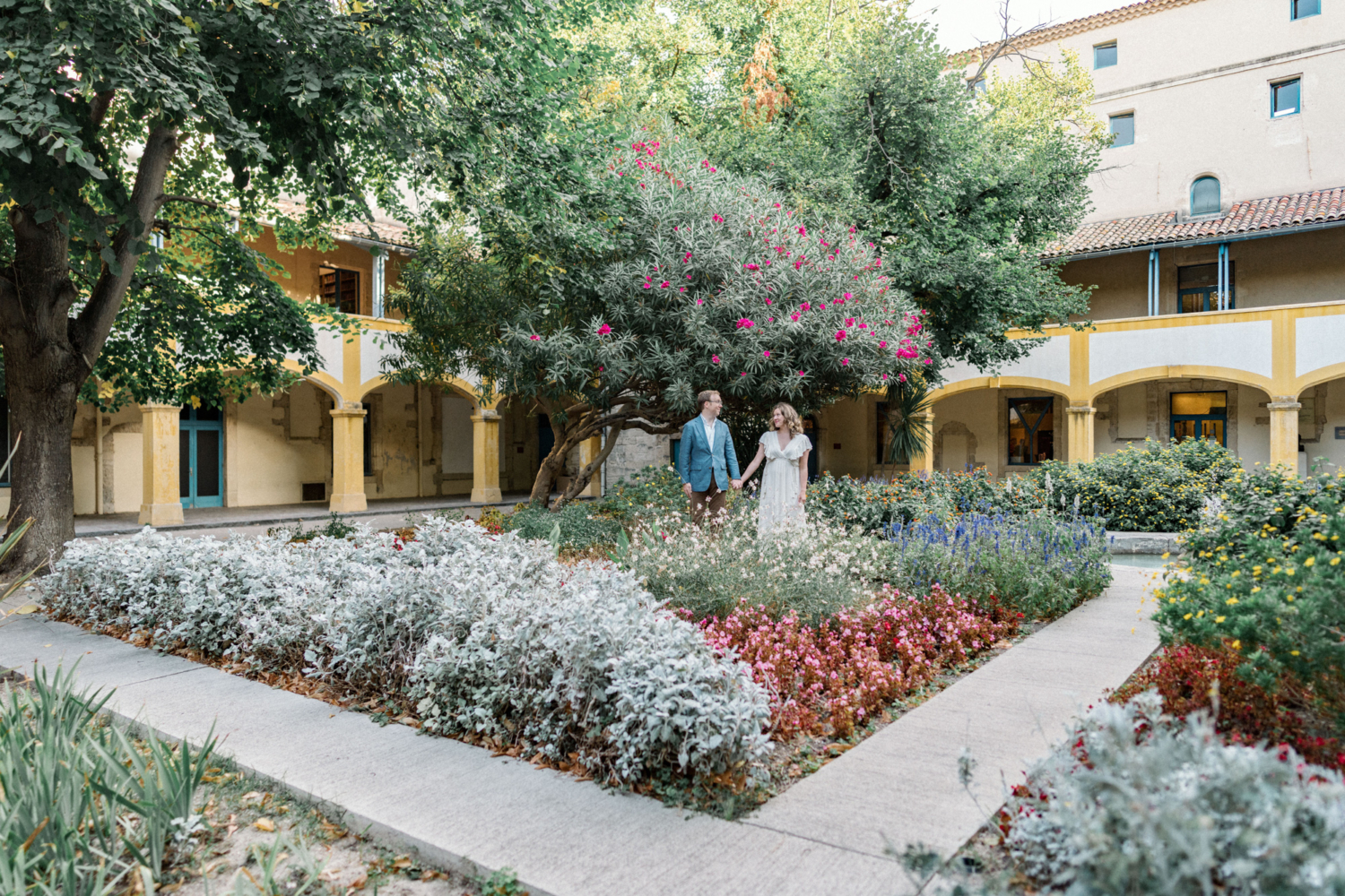 couple hold hands in colorful garden in arles france