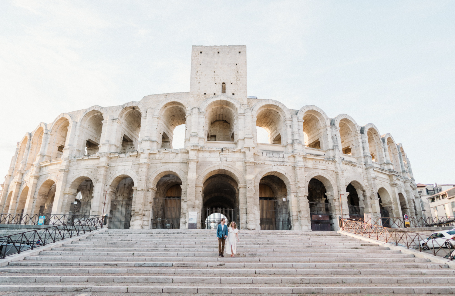 couple walk down stairs of roman amphitheatre in arles france