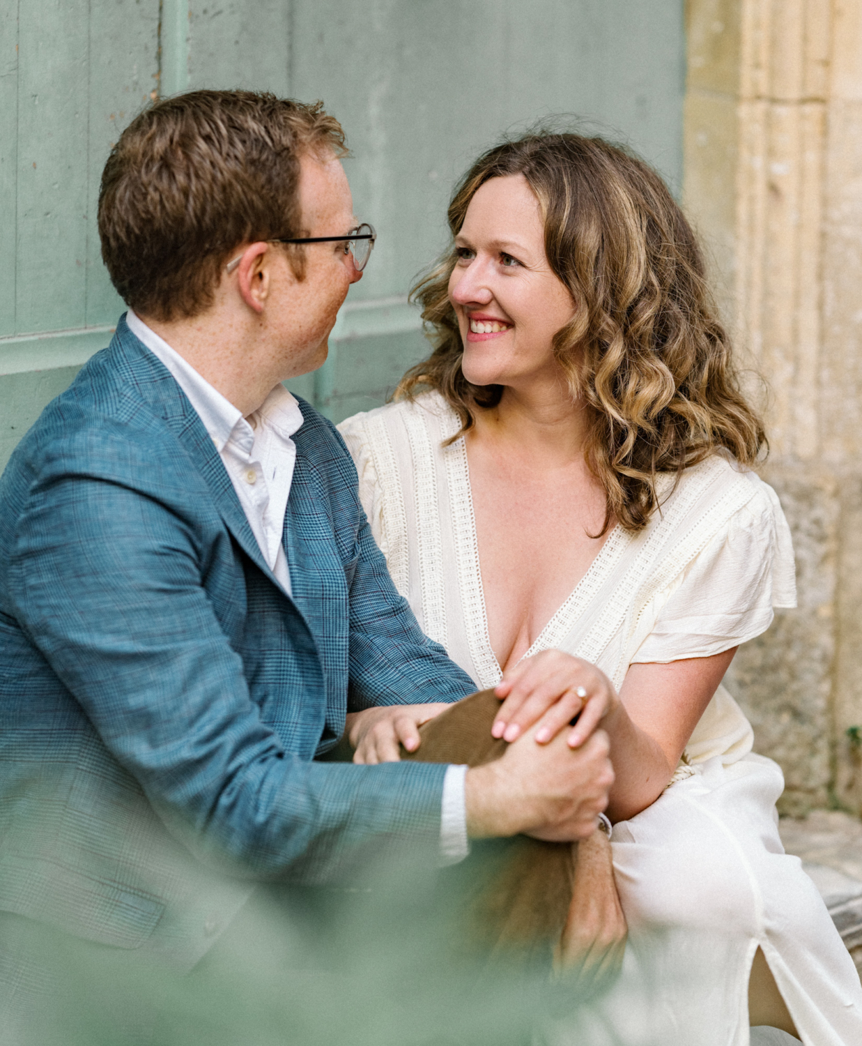 woman smiles at fiance seated on step