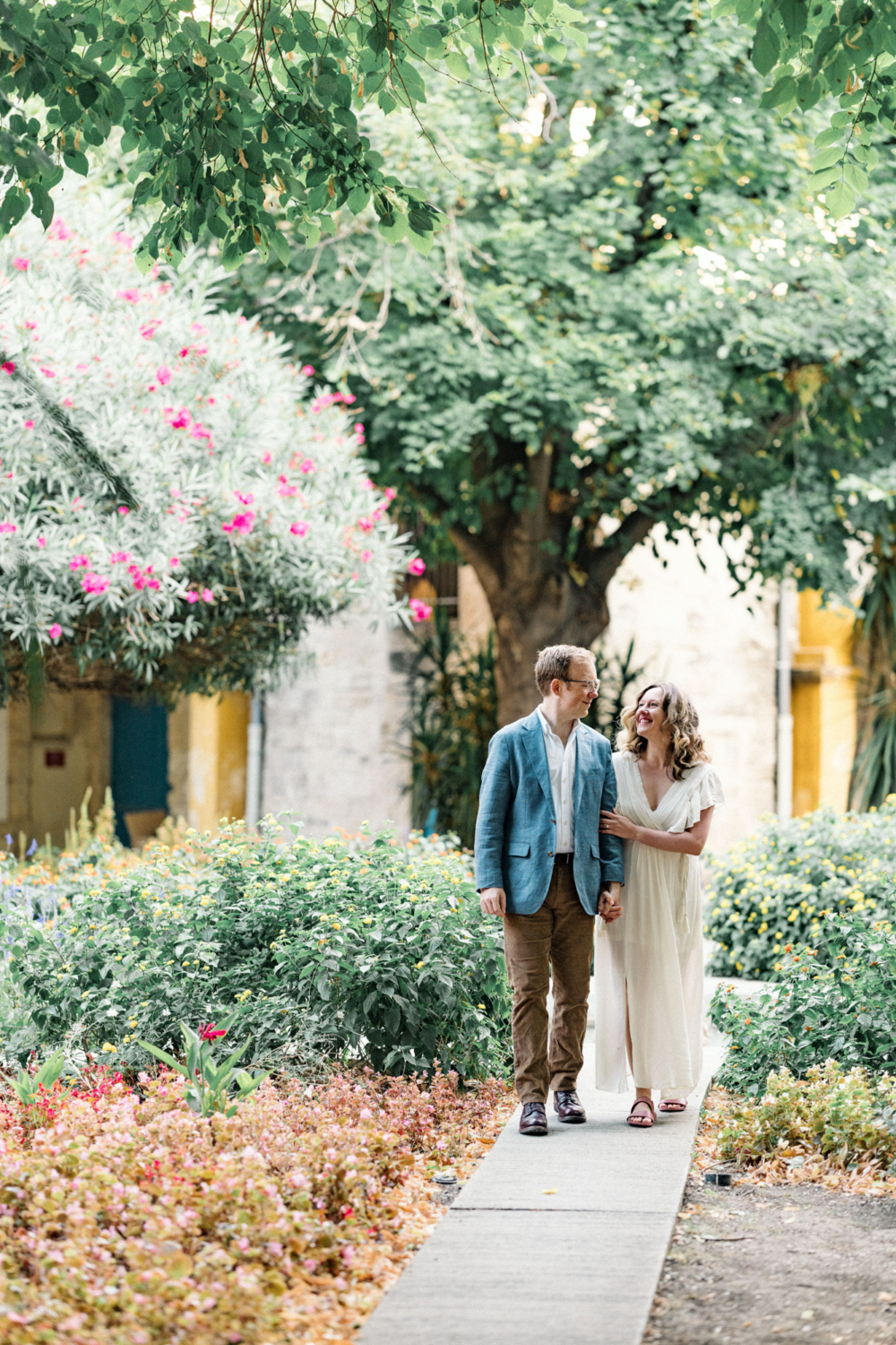 happy couple walk arm and arm in colorful garden