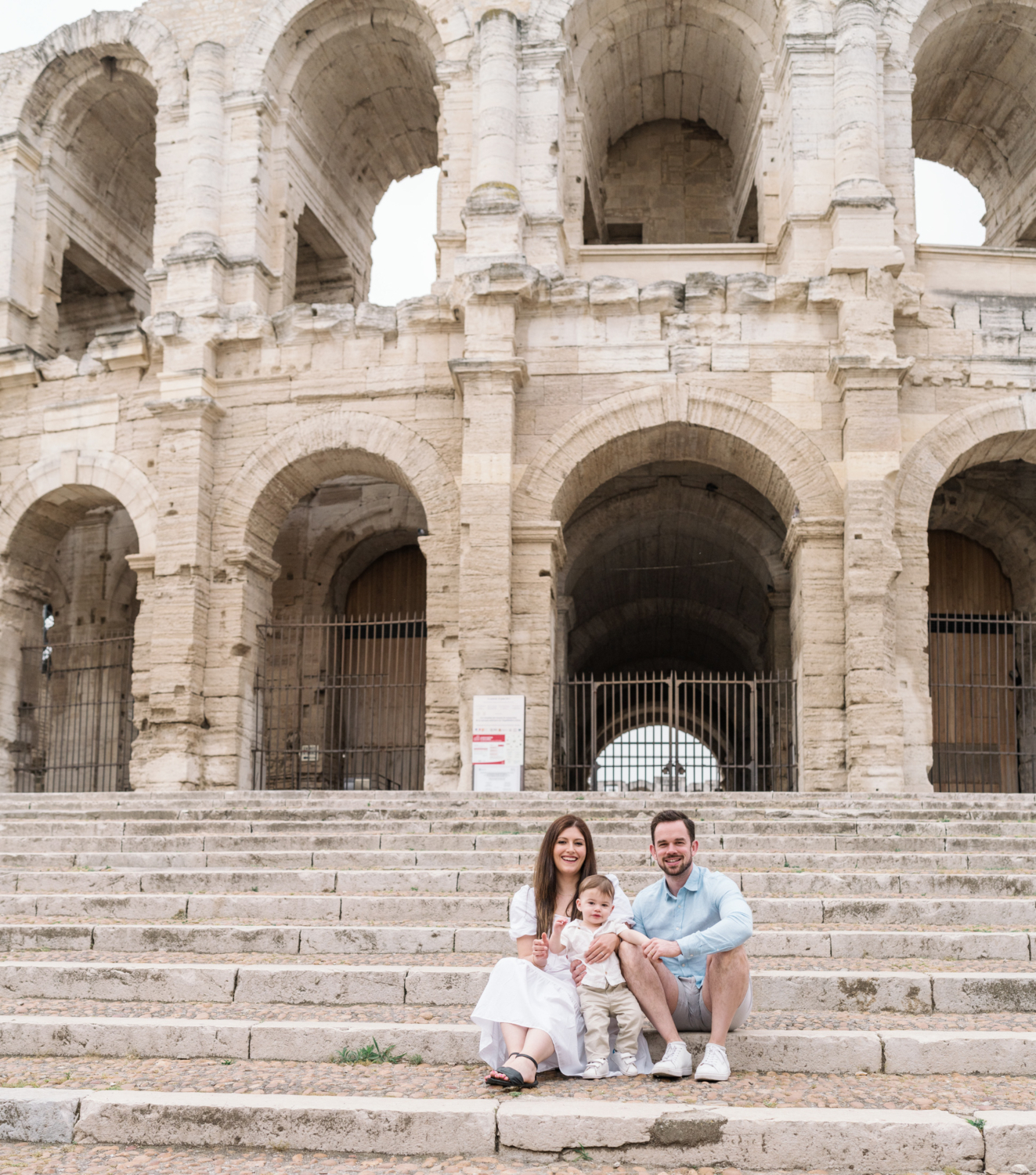 young couple with baby pose at roman amphitheater in arles france