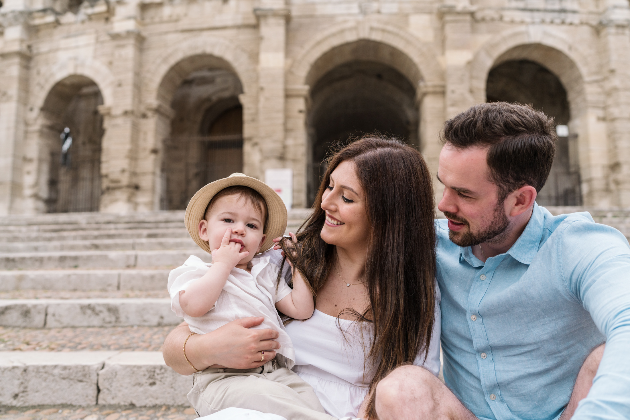 baby and parents pose at roman amphitheater in arles france