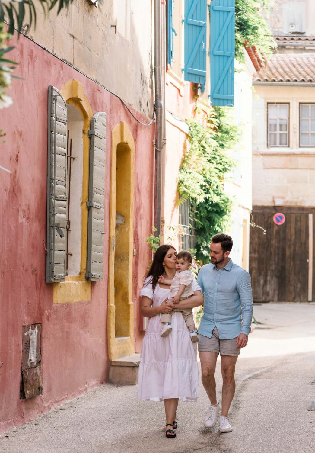 cute young family walk near colorful building in arles france