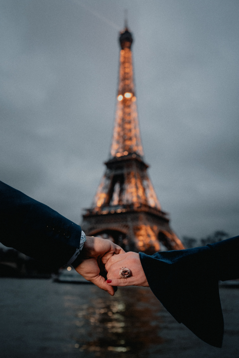 newly engaged couple engagement ring in front of the eiffel tower