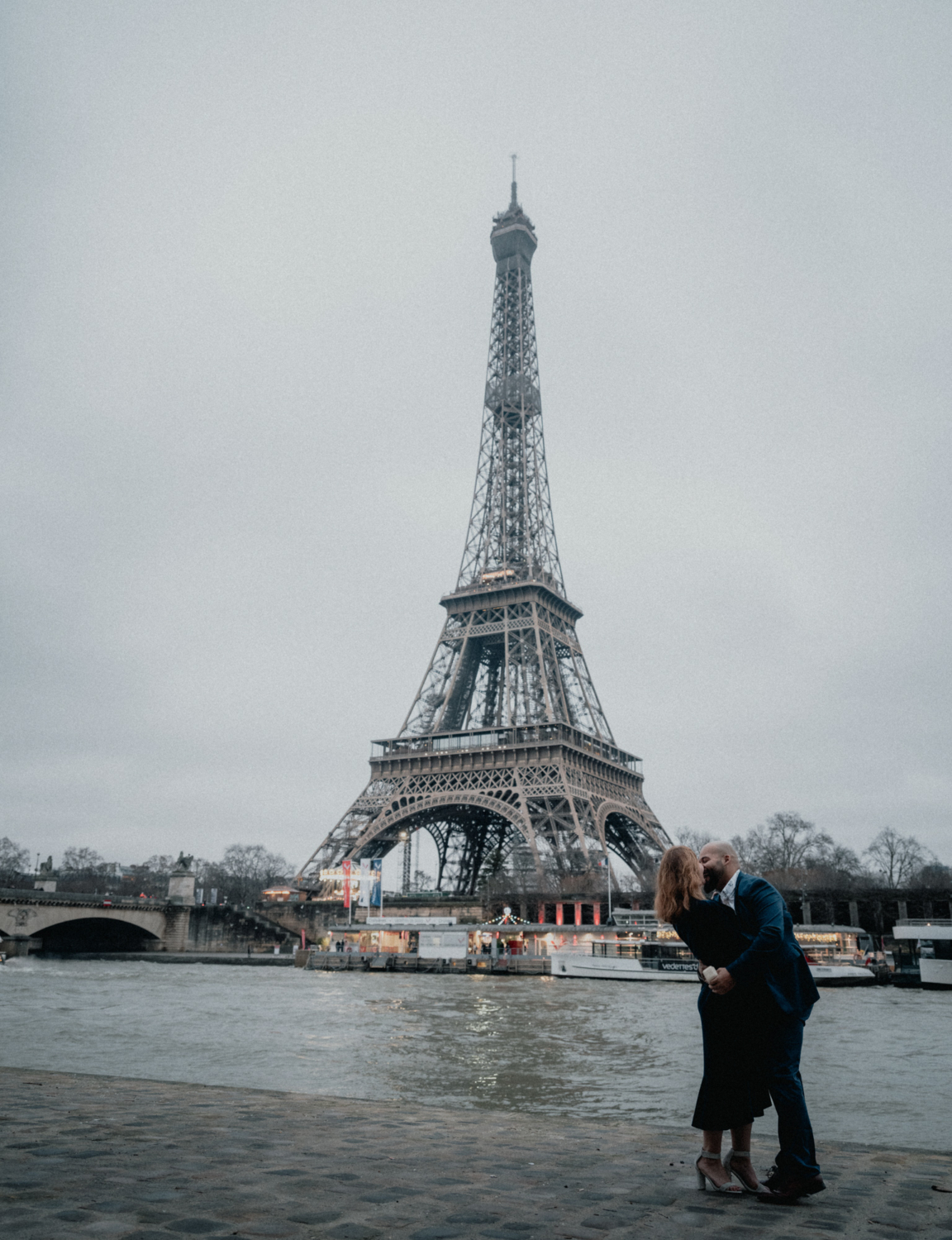 newly engaged couple kiss after surprise proposal in paris