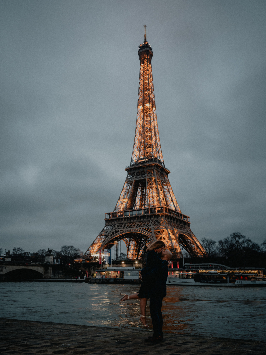 man lifts woman in air after paris surprise proposal with view of the eiffel tower