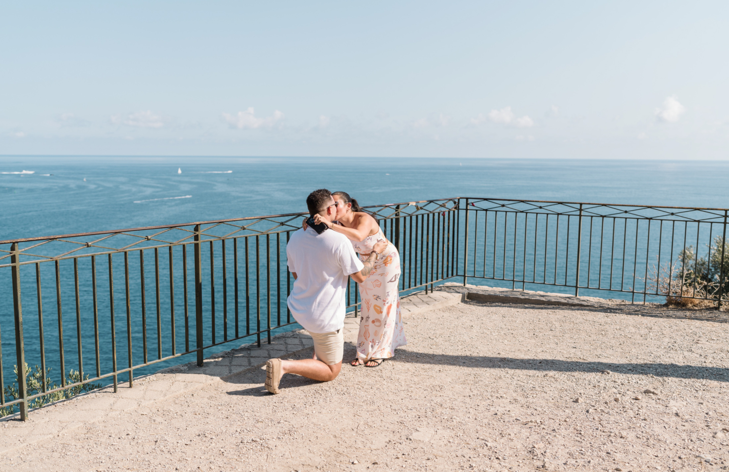 woman kisses man after he proposes with view of sea in nice france