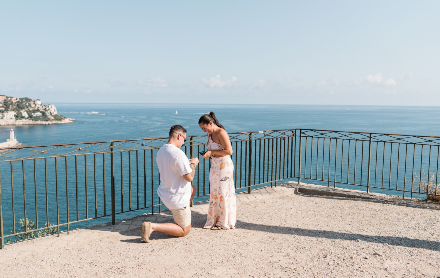 woman is shocked by surprise proposal with view of sea in nice france