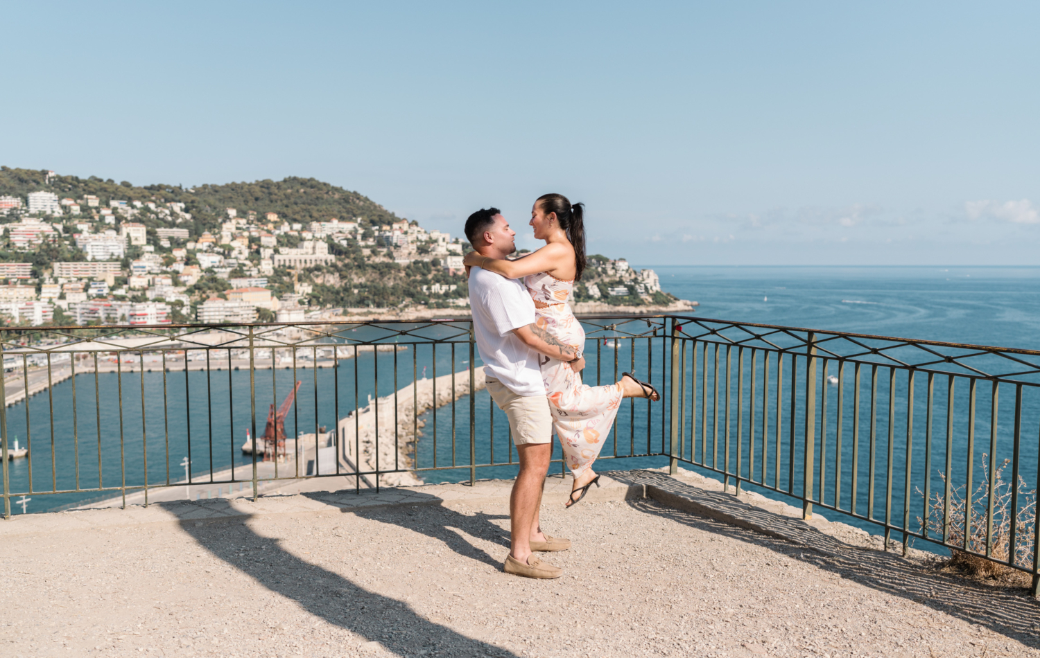 man lifts fiancee with view of sea in nice france