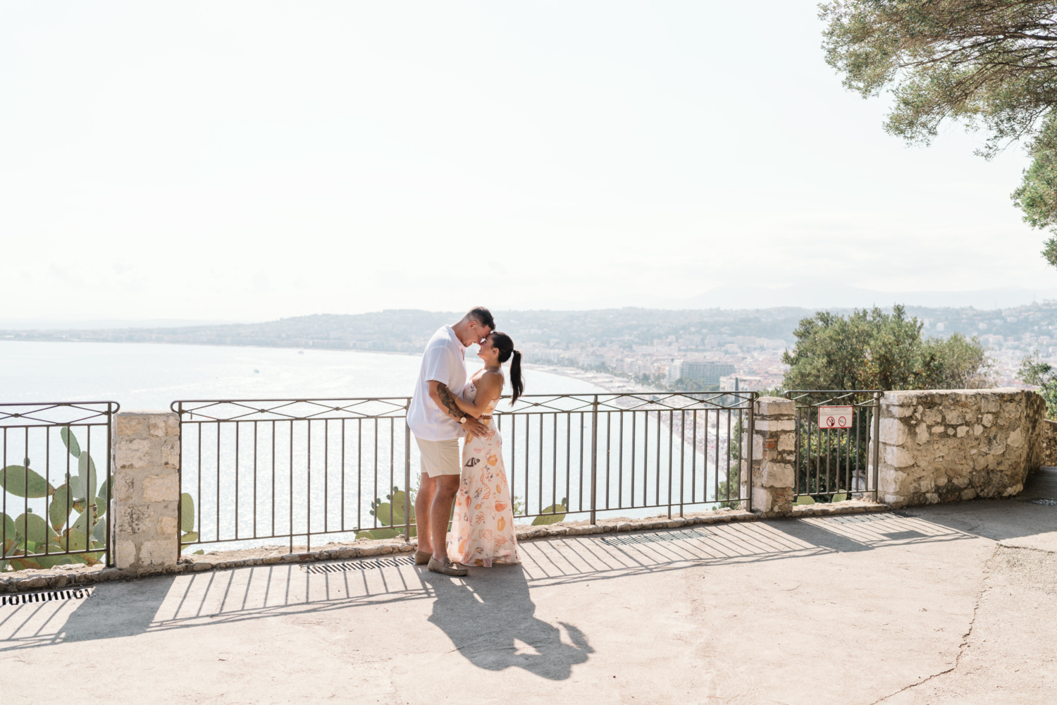 newly engaged couple embrace with view of sea in nice france