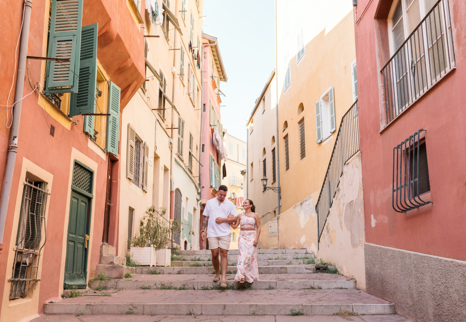 engaged couple walk armi in arm in old nice france