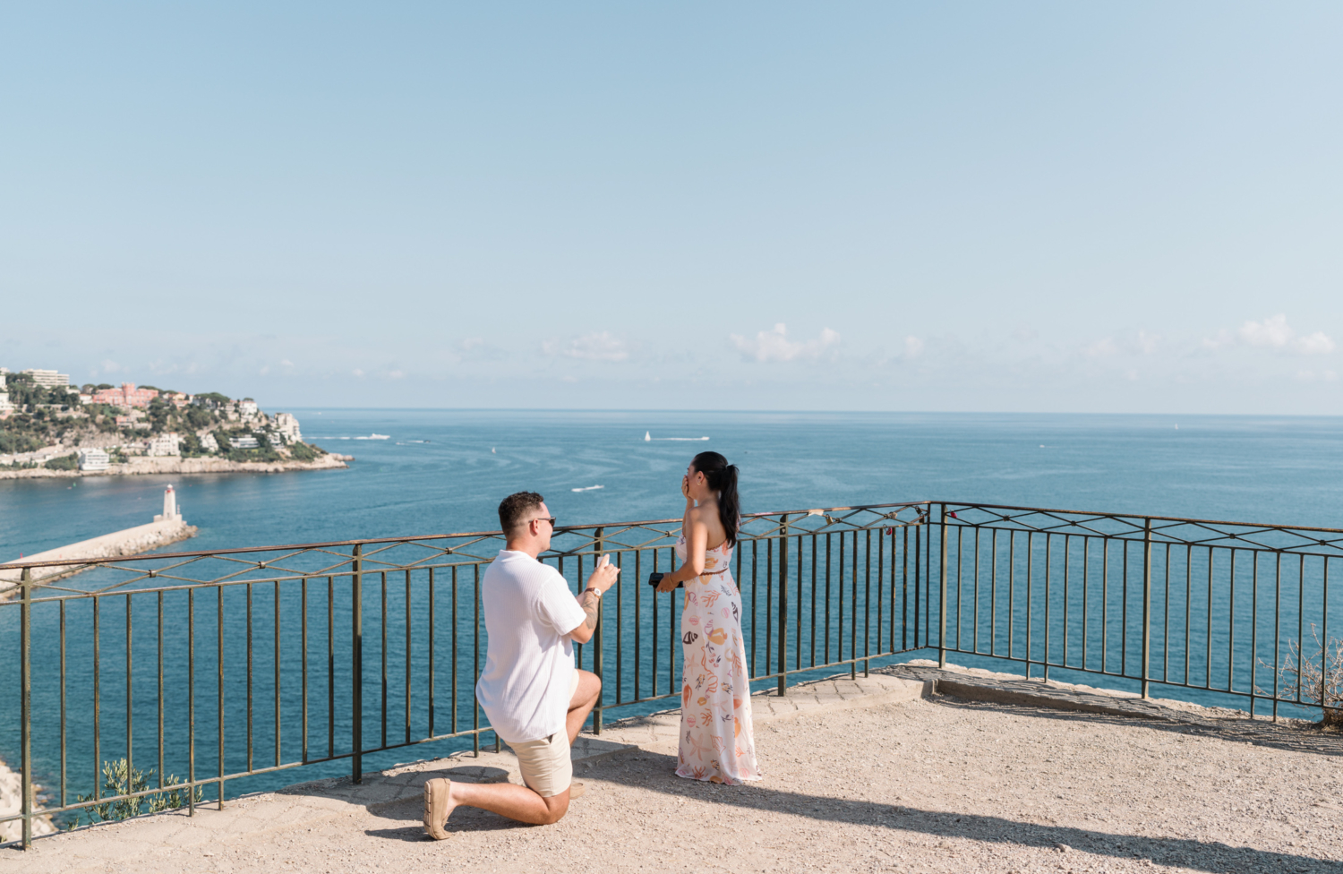 woman is overcome with shock as man proposes with view of sea in nice france